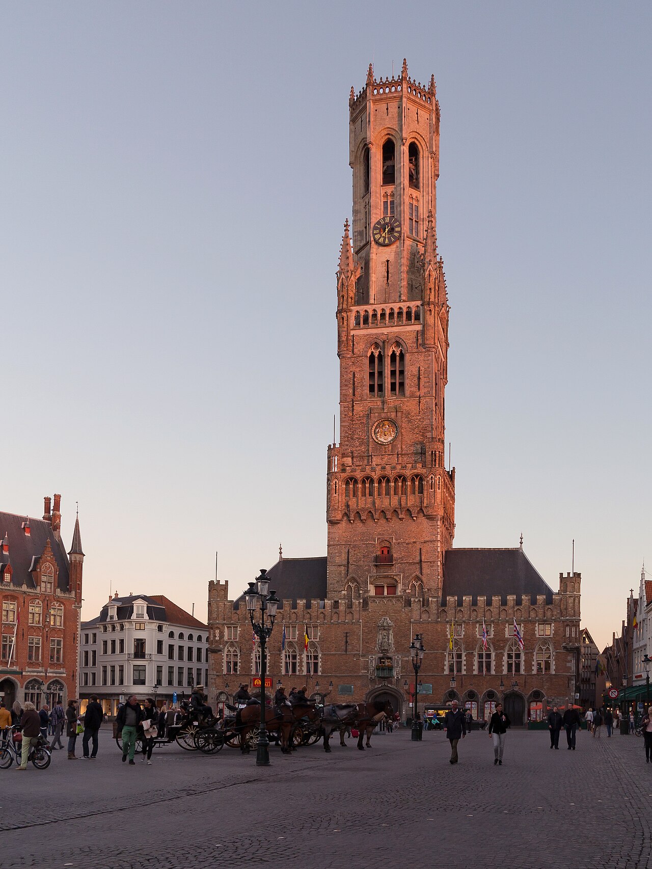 Torre do Belfort sobre o Markt de Bruges, com fachadas de casas de frontão escalonado