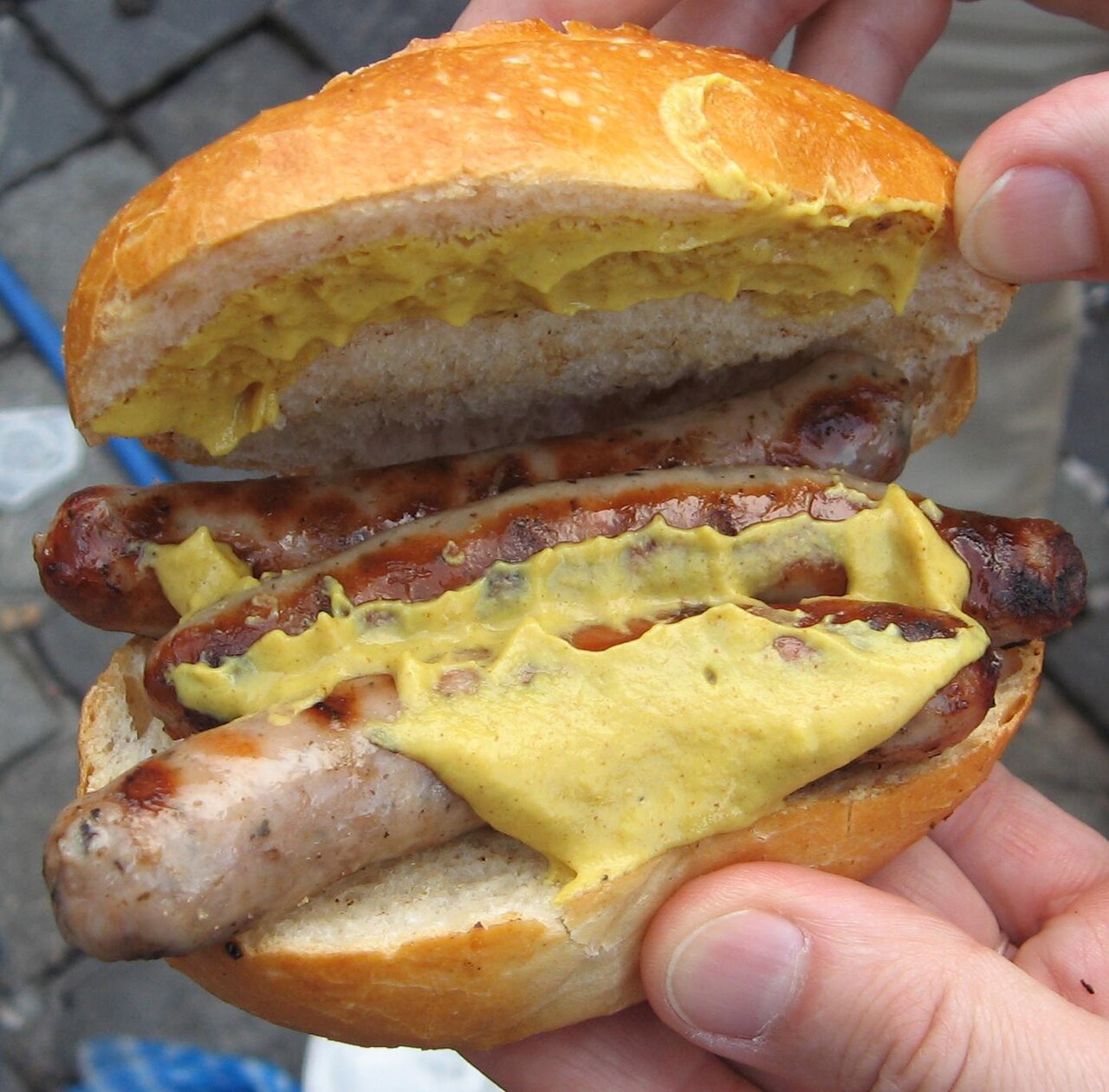Três salsichas Rostbratwurst de Nuremberg servidas dentro de um pão, o tradicional Drei im Weggla