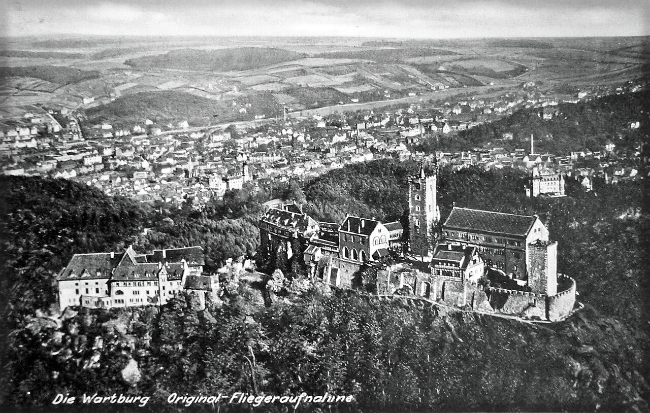 Vista aérea do Castelo de Wartburg sobre a colina arborizada acima de Eisenach