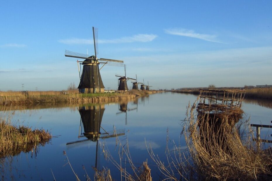 Fileira de moinhos de vento em Kinderdijk, Países Baixos, refletidos no canal