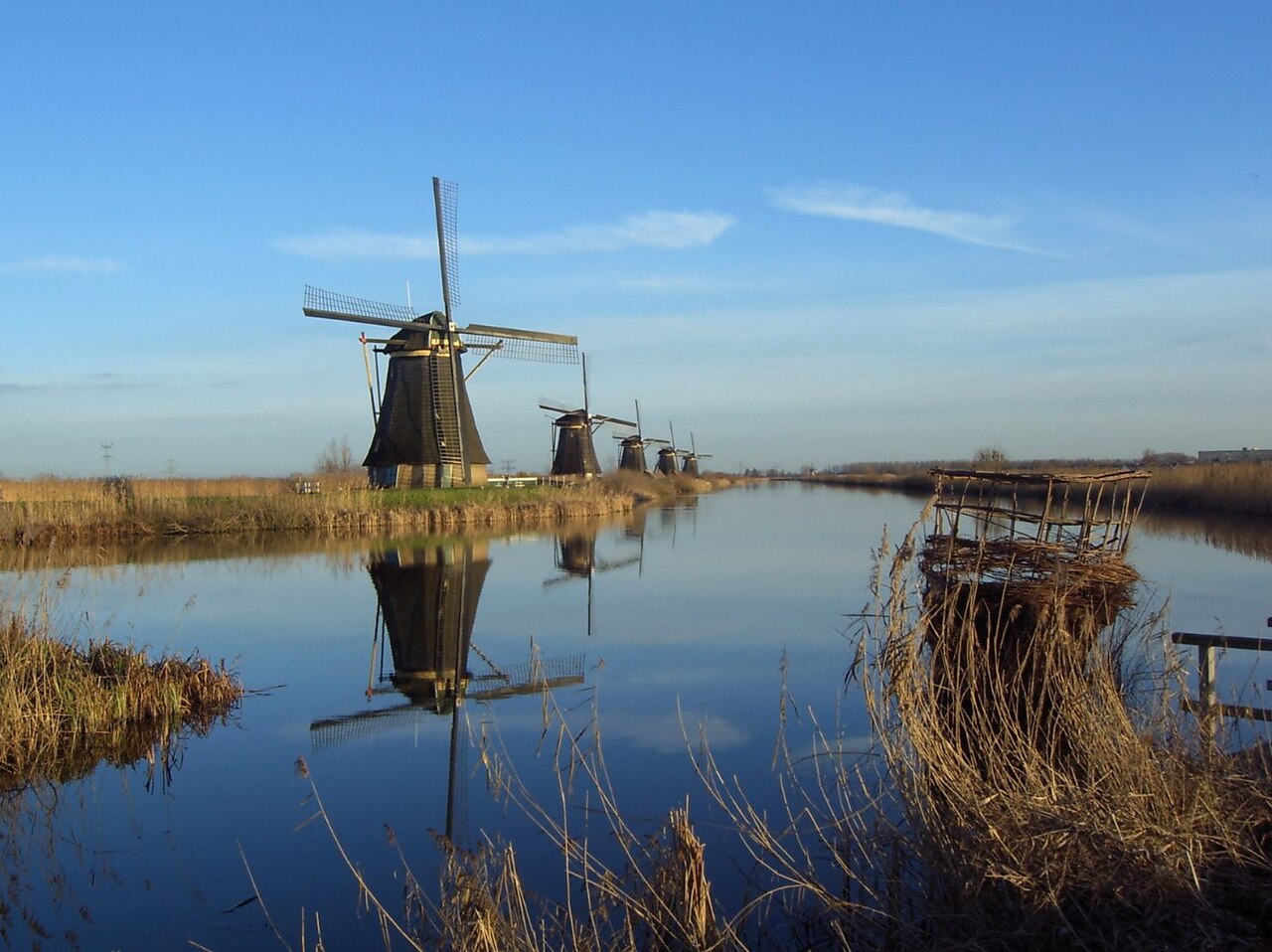 Fileira de moinhos de vento em Kinderdijk, Países Baixos, refletidos no canal