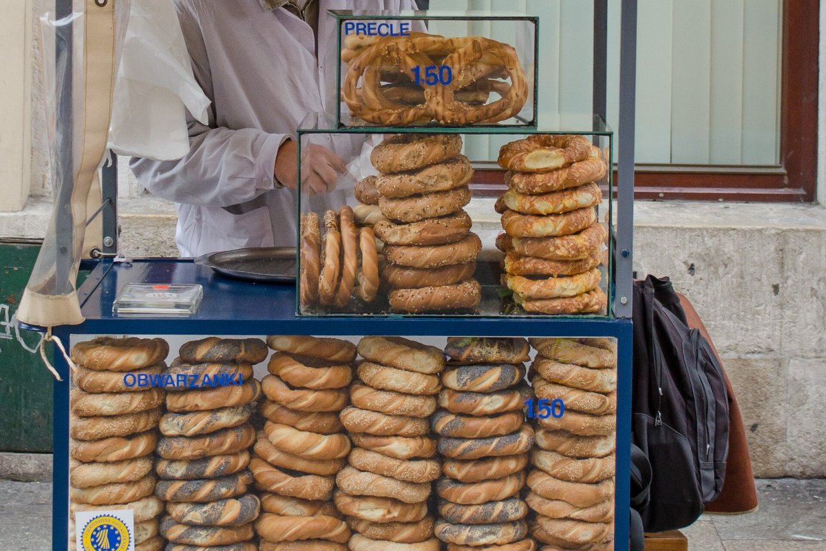 Vendedor de obwarzanek, a rosca trançada de Cracóvia, num carrinho azul de rua