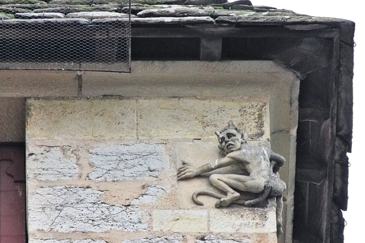 Estátua do diabinho agarrado à torre central da Pont Valentré, em Cahors