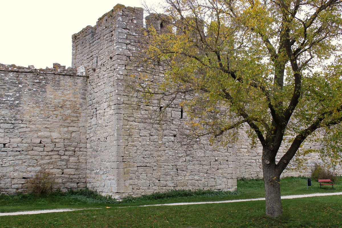 Trecho da muralha medieval de Visby, na ilha de Gotland, com torre de pedra e árvores